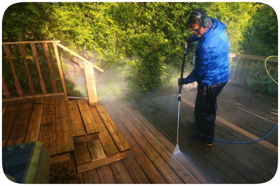 Homme nettoyant un patio en bois